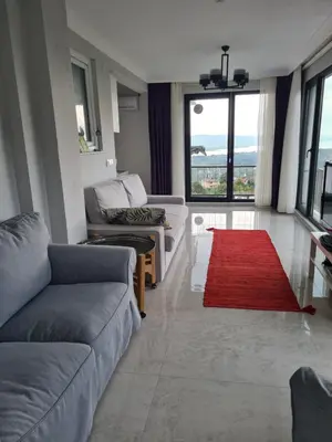 a living room with couches and a red rug at KD Apartments in Kartepe