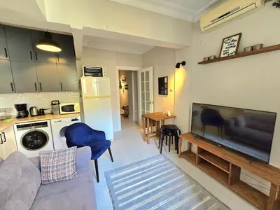 a living room with a couch and a tv and a kitchen at Osmanbey sweet homes in Istanbul