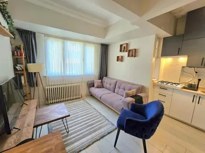 a living room with a purple couch and a blue chair at Osmanbey sweet homes in Istanbul
