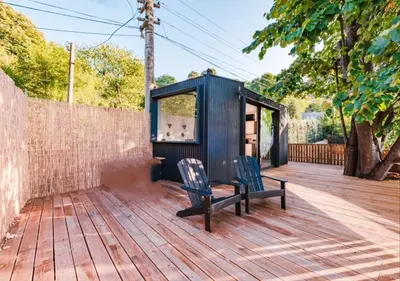 a wooden deck with a black shed and a bench at Kartepe LOFT in Kartepe