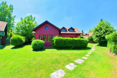 a red house with a green lawn in front of it at Villa Kirkpinar Sapanca in Sapanca