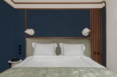 a bed with two white pillows and a blue wall at GentleTom in Istanbul