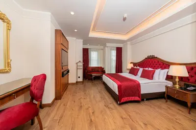 a large hotel room with a bed and a chair at Mukarnas Pera Hotel in Istanbul