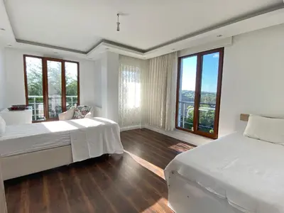 a bedroom with two beds and large windows at Wonderful Villa Airport 5 minutes in Arnavutköy