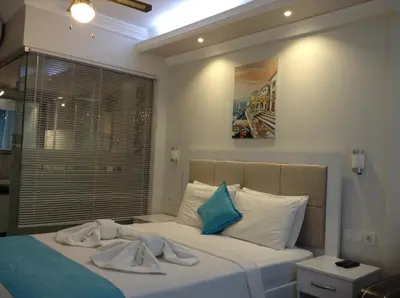 a bedroom with a bed with white and blue pillows at Mola Hotel in Marmara Adasi