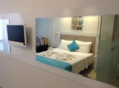 a bedroom with a bed with a tv on a wall at Mola Hotel in Marmara Adasi