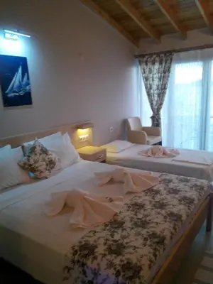 a hotel room with two beds and a chair at Mola Hotel in Marmara Adasi