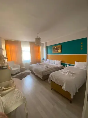 a hotel room with two beds and a chair at Pink OLD CITY 1 in Istanbul