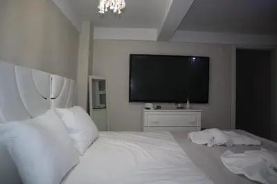 a bedroom with a white bed with a flat screen tv at Pink OLD CITY 1 in Istanbul
