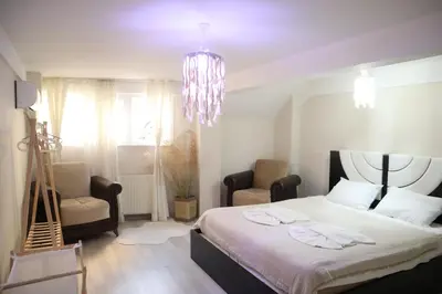 a bedroom with a bed and two chairs and a chandelier at Pink OLD CITY 1 in Istanbul