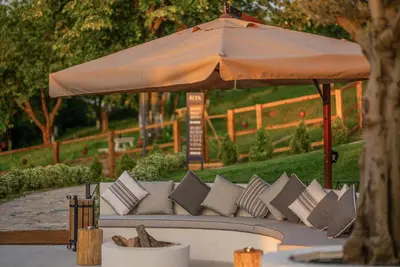 a couch with an umbrella and pillows at Alya Kartepe Villa Hotel in Kocaeli