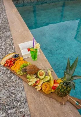 a tray of fruits and vegetables next to a swimming pool at Alya Kartepe Villa Hotel in Kocaeli