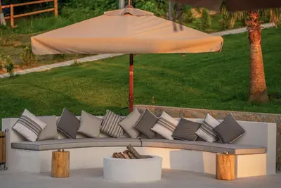 a couch with pillows sitting under an umbrella at Alya Kartepe Villa Hotel in Kocaeli