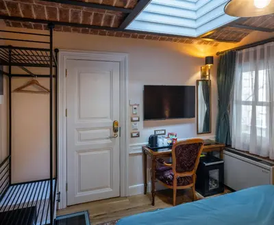 a bedroom with a bed and a desk and a window at Hotel Turkish House in Istanbul