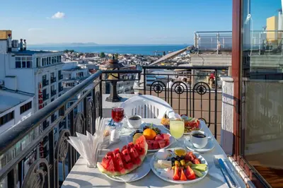 a table with plates of fruit and juice on a balcony at Hotel Erdal in Istanbul