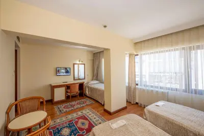 a hotel room with a bed and a desk and a window at Hotel Erdal in Istanbul