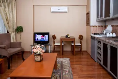 a living room with a kitchen and a table with a tv at Sultanahmet Suites in Istanbul