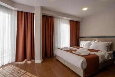 a bedroom with a large bed with red curtains at Navoris Hotel in Istanbul