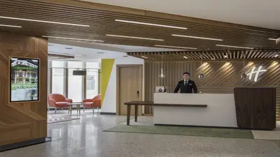 a man standing at a counter in an office lobby at Holiday Inn Istanbul Old City by IHG in Istanbul