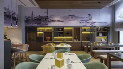 a restaurant with tables and chairs and a painting on the wall at Holiday Inn Istanbul Old City by IHG in Istanbul
