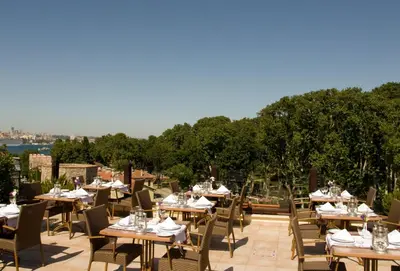 a restaurant with tables and chairs on a patio at Sirkeci Mansion in Istanbul