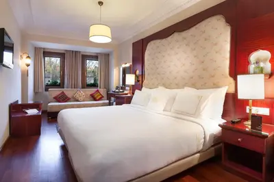 a bedroom with a large white bed and a couch at Sirkeci Mansion in Istanbul
