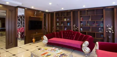 a living room with a red couch and book shelves at World Point Hotel Istanbul in Istanbul