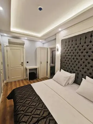 a bedroom with a large bed with a black headboard at Luxx Garden Hotel in Istanbul