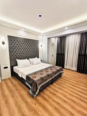 a bedroom with a large bed and a wooden floor at Luxx Garden Hotel in Istanbul
