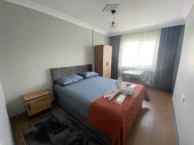 a small bedroom with a bed and a table at ANA GÜNEY Apart Otel in Nilüfer
