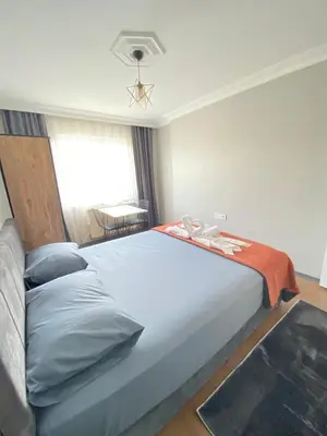 a bedroom with a large white bed and a window at ANA GÜNEY Apart Otel in Nilüfer