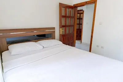 a bedroom with a white bed with a wooden headboard at Kaplan Cosy Flat - All air conditioned & Heated 3 Bedrooms in the City in Istanbul
