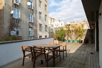 a wooden table and chairs on a balcony with buildings at NOA - Ali Hoca 6 in Istanbul