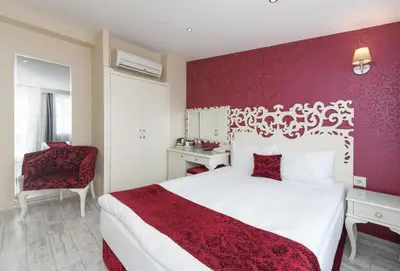 a bedroom with a white bed and a red wall at Dream Bosphorus Hotel in Istanbul