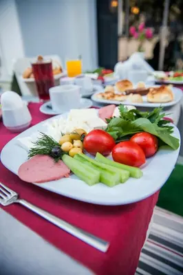 a plate of food on a table with tomatoes and vegetables at Dream Bosphorus Hotel in Istanbul