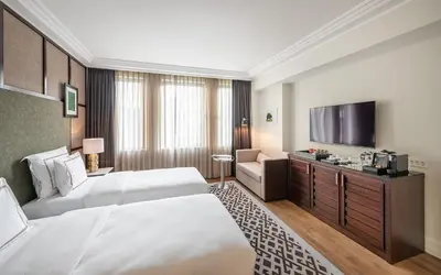a hotel room with two beds and a flat screen tv at The Stay Boulevard Nisantasi in Istanbul
