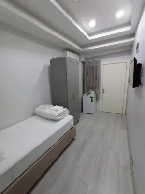 a white room with a bed and a door at Emin Konak Hotel in Istanbul