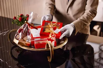 a person holding a tray with a christmas present at Vakko Hotel and Residence in Istanbul
