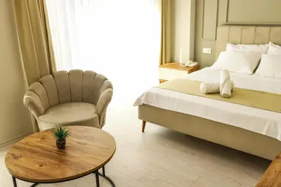 a bedroom with a bed and a chair and a table at PETRA HOTEL TUZLA in Tuzla