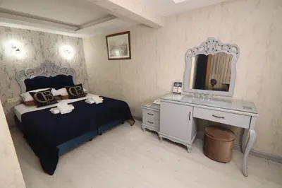 a bedroom with a bed and a dresser and a mirror at BALPETEK HOTEL in Istanbul