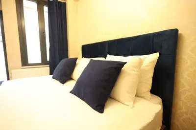 a bed with white pillows and a black headboard at Asmali Hotel in Istanbul