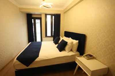 a bedroom with a bed with white sheets and pillows at Asmali Hotel in Istanbul