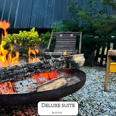 a fire pit in a yard with a bench and flames at VADİ BUNGALOV SAPANCA in Sapanca