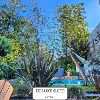 a pool in a garden with a sign that says believe stuff at VADİ BUNGALOV SAPANCA in Sapanca