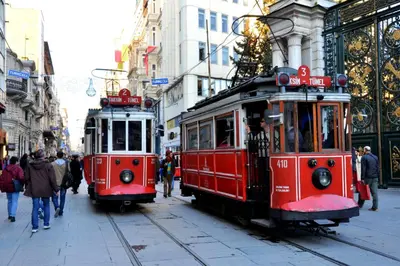 two red trolley cars on a city street at Ragip Pasha Apartments in Istanbul