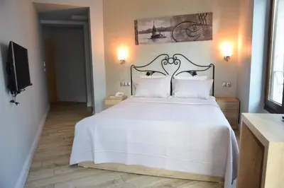 a bedroom with a white bed and a television at Ragip Pasha Apartments in Istanbul