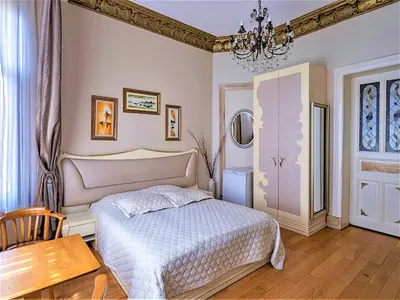 a bedroom with a bed and a table and a chandelier at Ragip Pasha Apartments in Istanbul