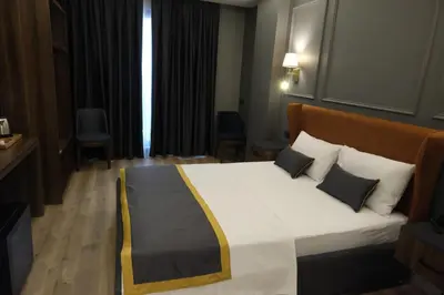a bedroom with a large bed with white sheets and pillows at The Pearl Airport Hotel in Arnavutköy