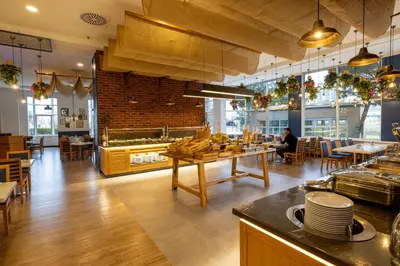 a restaurant with tables and chairs and a brick wall at WOW Airport Hotel in Istanbul