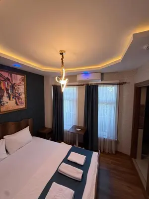a bedroom with a bed and a chandelier at La Vien Hotel Old City in Istanbul